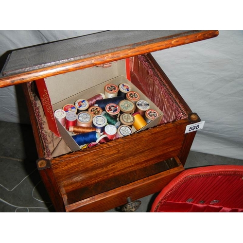 598 - A sewing box on legs, an oak magazine rack, an old leather briefcase and 2 wicker sewing baskets.