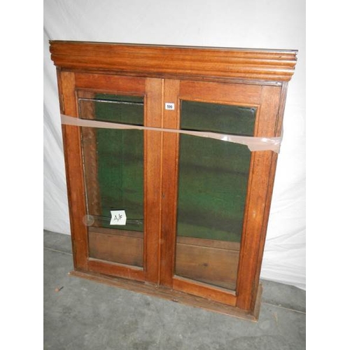 599 - A glass fronted 2 door cabinet with shelves (glass needs replacing) 115 x 98 x 30 cm.