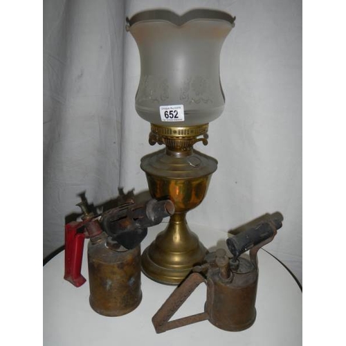 652 - An old brass oil lamp complete with chimney.