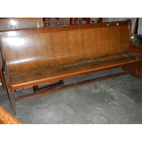 656 - A long old church pew, approximately 210 cm wide.