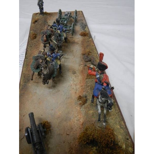 518 - A diorama featuring 4 horses pulling a cannon and soldiers on horseback.