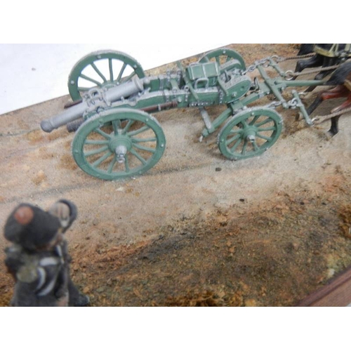 518 - A diorama featuring 4 horses pulling a cannon and soldiers on horseback.