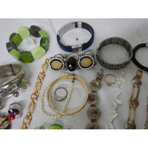 535 - A mixed lot of costume jewellery including necklaces, bangles, rings etc and a small clock.