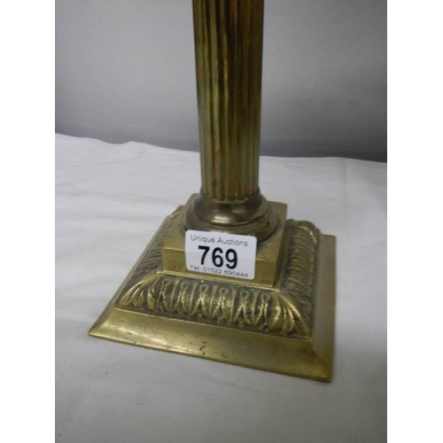 769 - A brass oil lamp on cast base with reeded column, brass font  complete with burner, chimney and etch... 