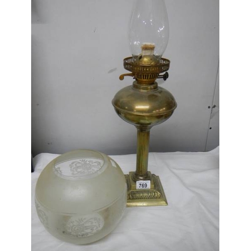 769 - A brass oil lamp on cast base with reeded column, brass font  complete with burner, chimney and etch... 