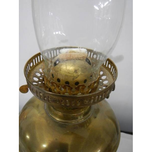 769 - A brass oil lamp on cast base with reeded column, brass font  complete with burner, chimney and etch... 