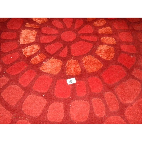 807 - A good quality rug in red, 183 x 122cm.