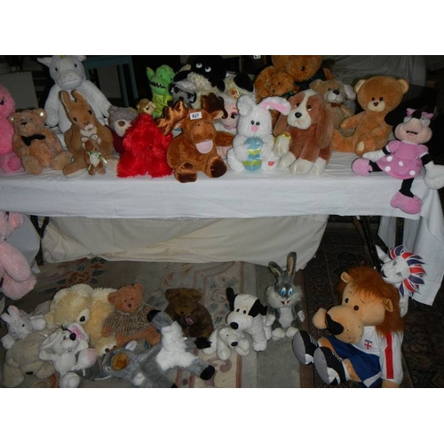 827 - A large quantity of soft toys including Bugs Bunny, MIckey Mouse etc., In excess of 30 in total.