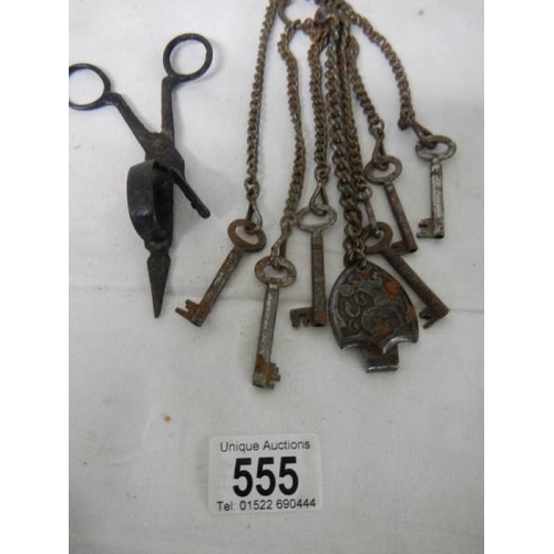 555 - A vintage steel chatelaine with various old keys.