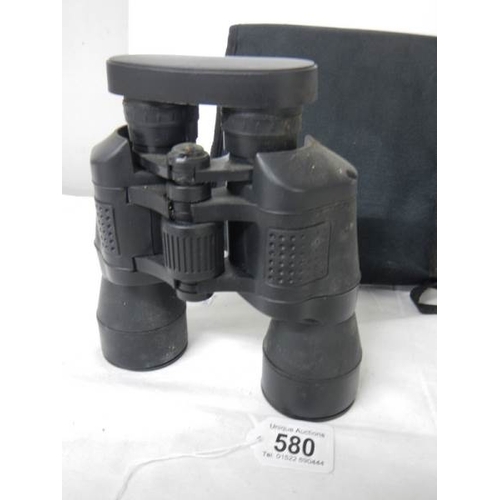 580 - A cased pair of 7 x 50 binoculars with lens covers and fitted compass.