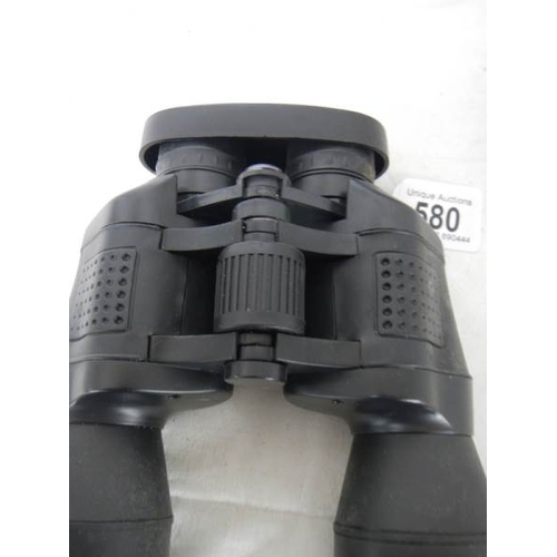 580 - A cased pair of 7 x 50 binoculars with lens covers and fitted compass.