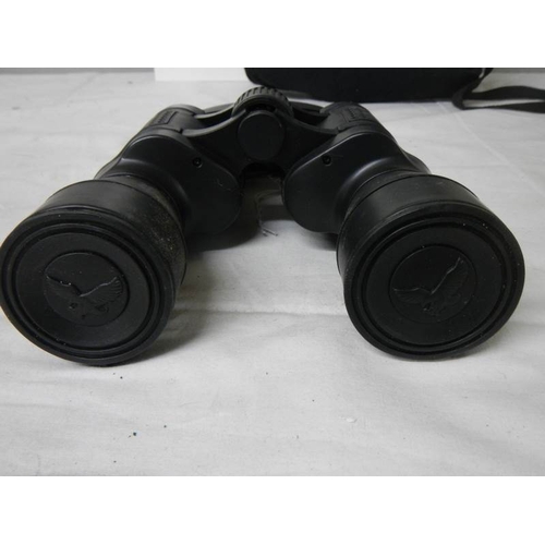 580 - A cased pair of 7 x 50 binoculars with lens covers and fitted compass.