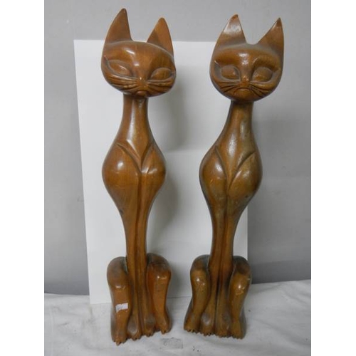 602 - A pair of tall wooden cat figures.