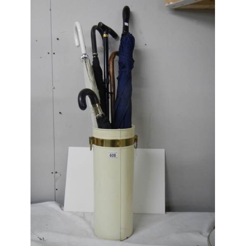 608 - A metal stick stand with 4 umbrella's and 2 walking sticks.