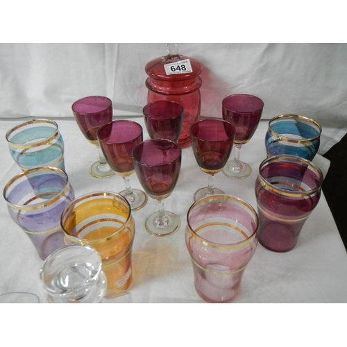 648 - 2 good sets of coloured glasses, a cranberry glass lidded jar, an etched decanter and 2 glasses.