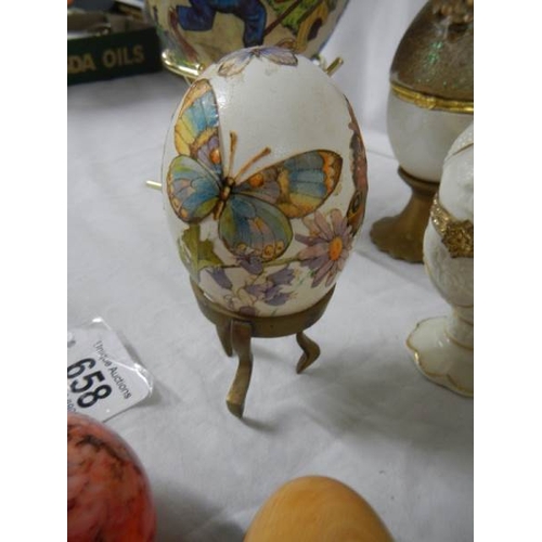 658 - A mixed lot of decorative collector's eggs in china and other materials.