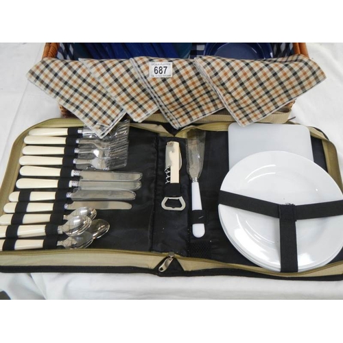 687 - A picnic basket with contents and cutlery.