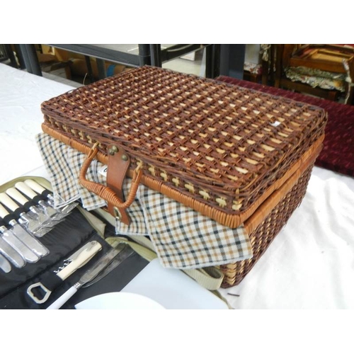 687 - A picnic basket with contents and cutlery.