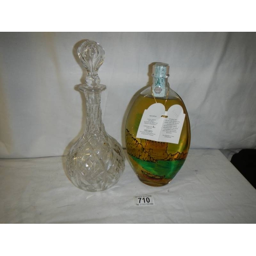 710 - An early 20th century cut glass decanter and an unopened bottle of alcohol.