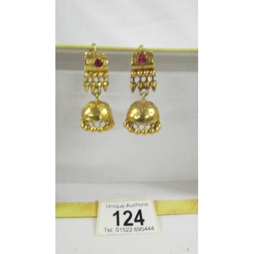 124 - A pair of (test as 24ct gold) pendant earrings set rubies.  10.4 grams.