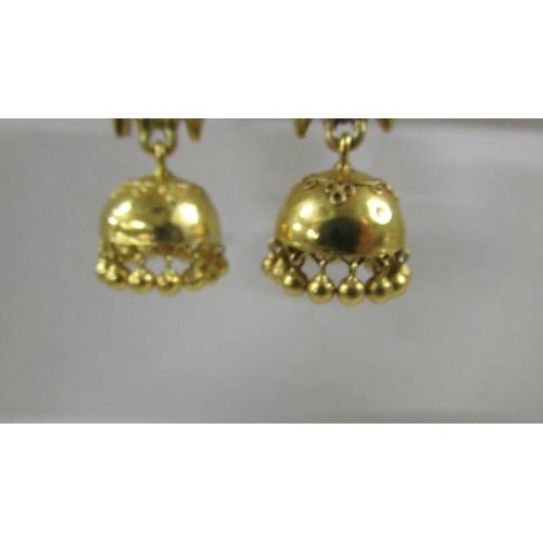 124 - A pair of (test as 24ct gold) pendant earrings set rubies.  10.4 grams.