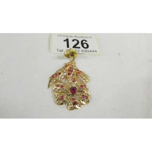 126 - A stone set floral design pendant (tests as 24ct gold).