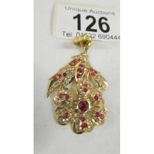 126 - A stone set floral design pendant (tests as 24ct gold).