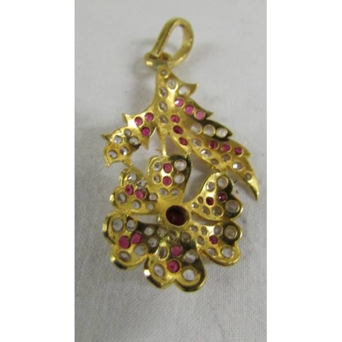 126 - A stone set floral design pendant (tests as 24ct gold).