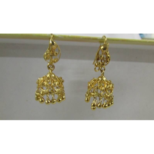 129 - A pair of pendant earrings, (test as 24 ct gold) 8.8 grams.