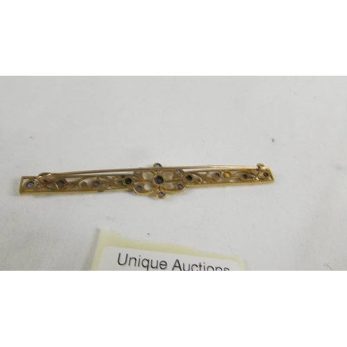 130 - A stone set brooch.  ( tests as 24ct gold).