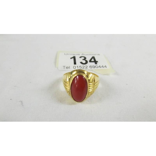 134 - A ring set red stone, size T (tests as 24 ct gold).