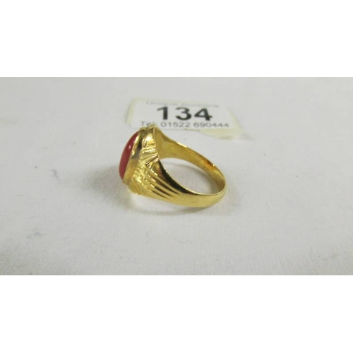 134 - A ring set red stone, size T (tests as 24 ct gold).