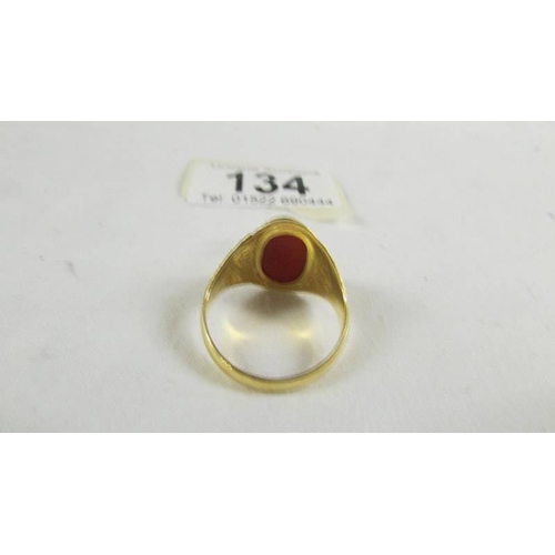134 - A ring set red stone, size T (tests as 24 ct gold).