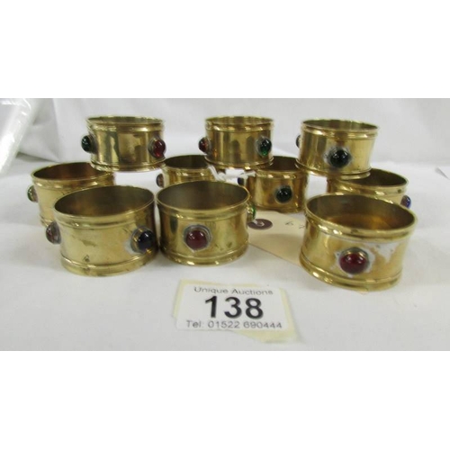 138 - A set of 10 arts and crafts brass napkin rings with multi coloured bead insets.