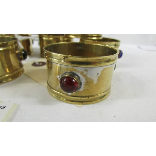 138 - A set of 10 arts and crafts brass napkin rings with multi coloured bead insets.