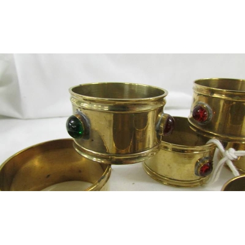 138 - A set of 10 arts and crafts brass napkin rings with multi coloured bead insets.