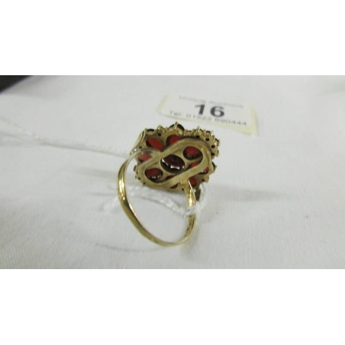 16 - A 9ct gold ring set garnets, size T.