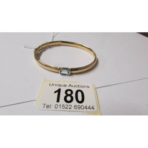 180 - A 9ct gold and aquamarine bangle, 10 grams (some dints on inside).