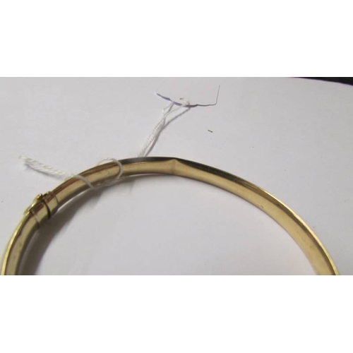 180 - A 9ct gold and aquamarine bangle, 10 grams (some dints on inside).
