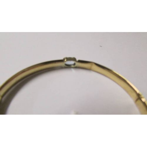 180 - A 9ct gold and aquamarine bangle, 10 grams (some dints on inside).