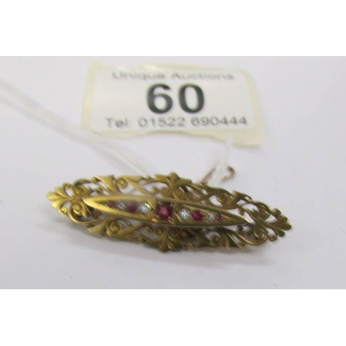 60 - An antique ruby and diamond brooch in 15 carat hall marked gold with attached safety chain.