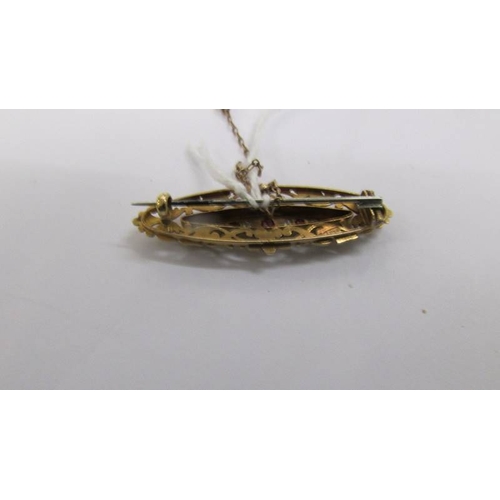 60 - An antique ruby and diamond brooch in 15 carat hall marked gold with attached safety chain.