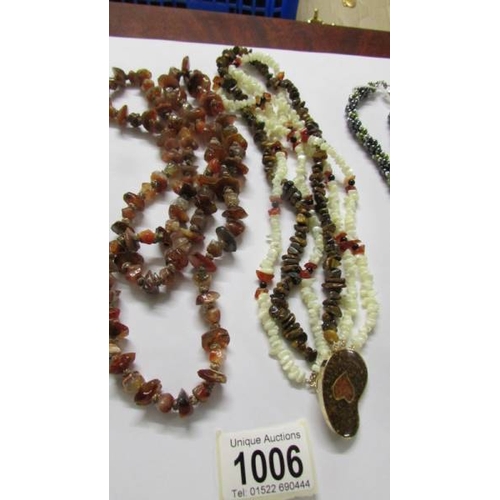 1006 - A Tigers eye and mother of pearl necklace with a heart design clasp, together with an agate necklace... 