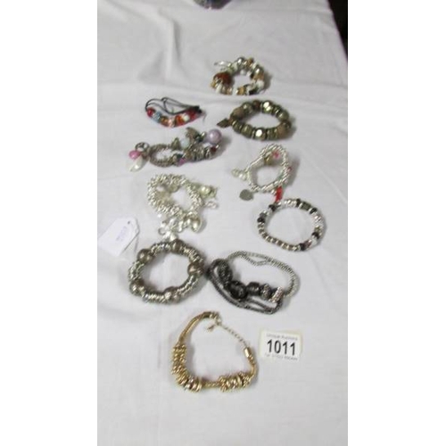 1011 - A collection of 9 Pandora style bracelets with charms etc.,