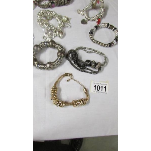 1011 - A collection of 9 Pandora style bracelets with charms etc.,