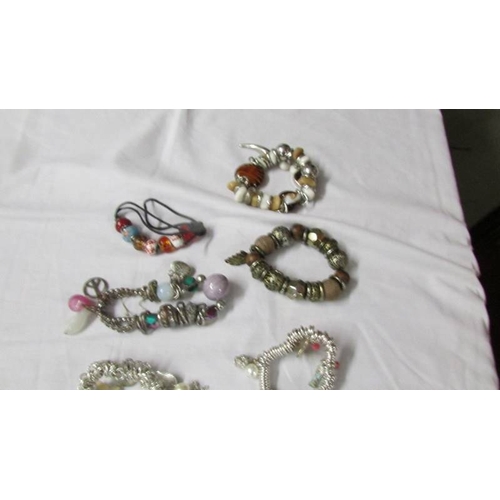 1011 - A collection of 9 Pandora style bracelets with charms etc.,