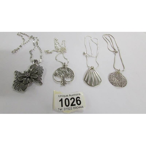 1026 - 4 assorted silver pendants.