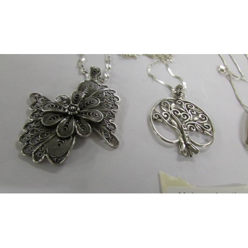 1026 - 4 assorted silver pendants.