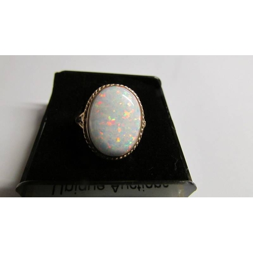 2002 - A large oval opal 9ct gold ring size O half, (opal reconstituted).