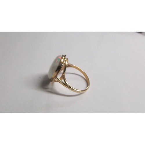 2002 - A large oval opal 9ct gold ring size O half, (opal reconstituted).